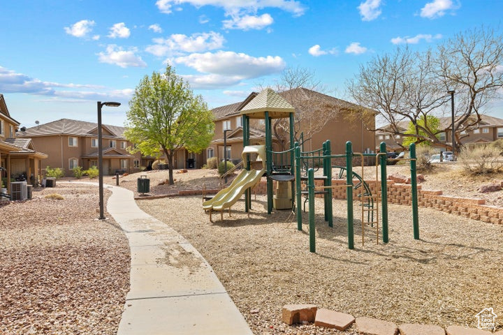 Community jungle gym with central air condition unit and a residential view