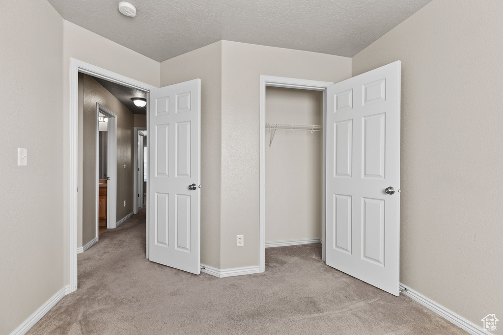 Unfurnished bedroom featuring carpet, baseboards, and a closet