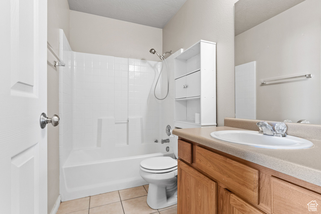 Full bathroom featuring  shower combination, tile patterned flooring, toilet, and vanity