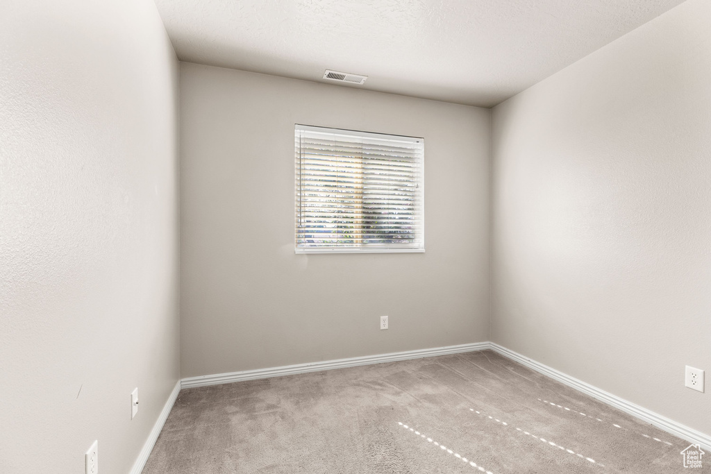 Carpeted empty room featuring baseboards