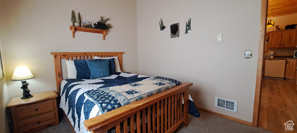 Carpeted bedroom featuring baseboards and visible vents