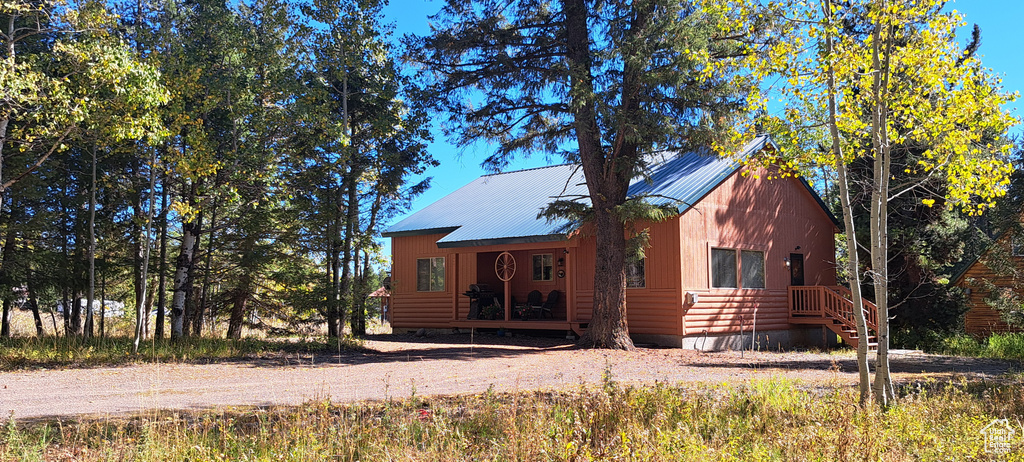 View of front of house with crawl space and metal roof