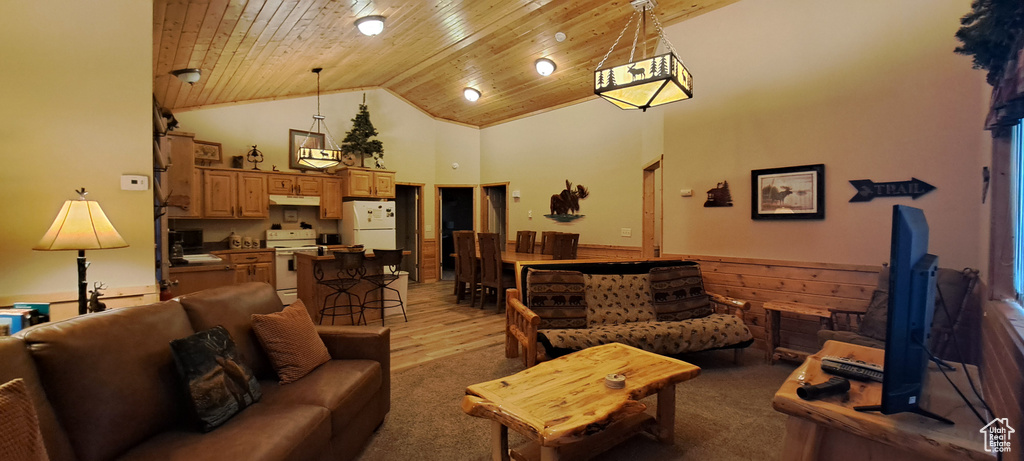 Living area with a wainscoted wall, high vaulted ceiling, wood walls, and wood ceiling