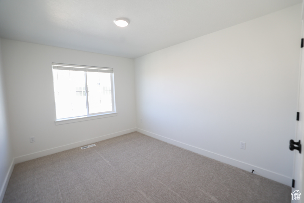 Unfurnished room featuring carpet floors, baseboards, and visible vents