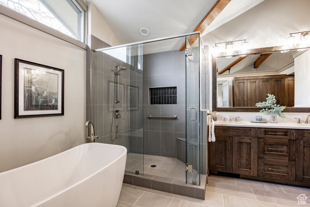Bathroom with a shower stall, double vanity, a sink, a freestanding bath, and tile patterned flooring