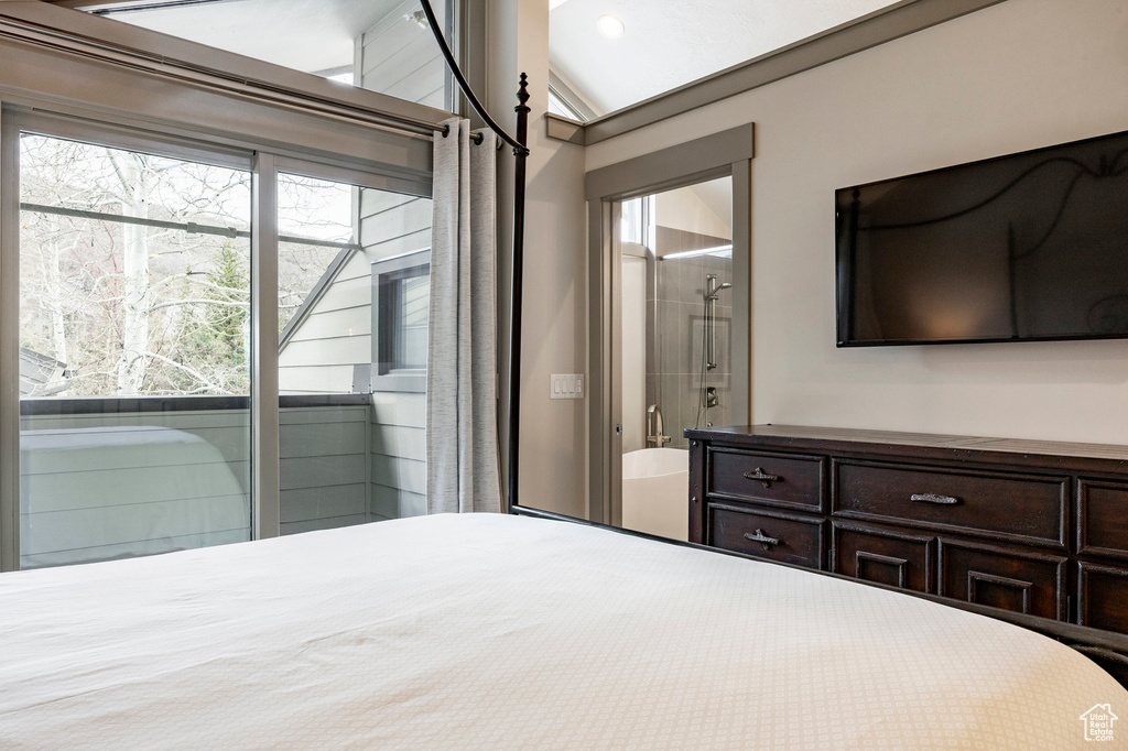 Bedroom featuring connected bathroom and lofted ceiling