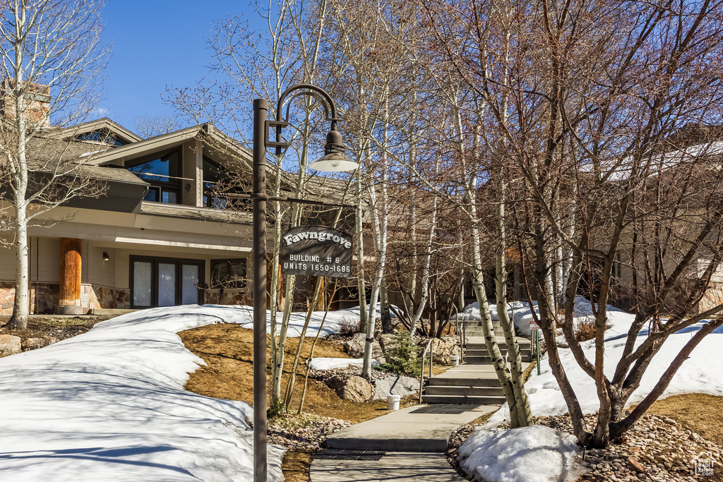 View of front of house with stone siding, driveway, and french doors