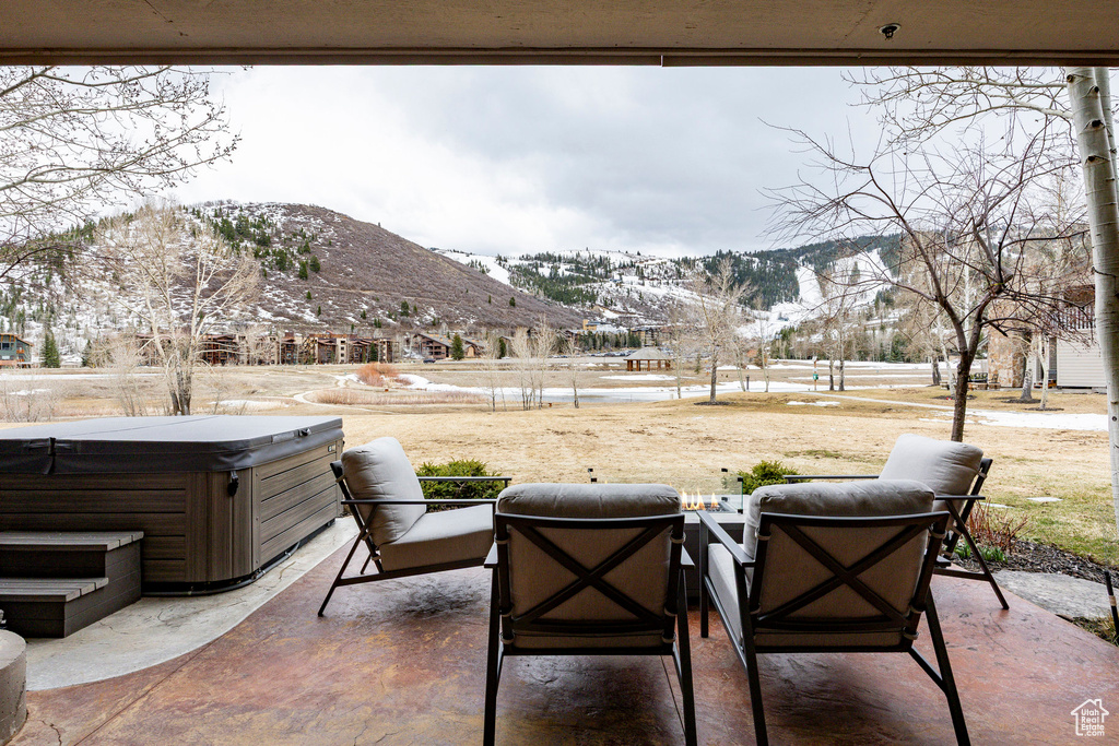 View of patio featuring a hot tub and a mountain view