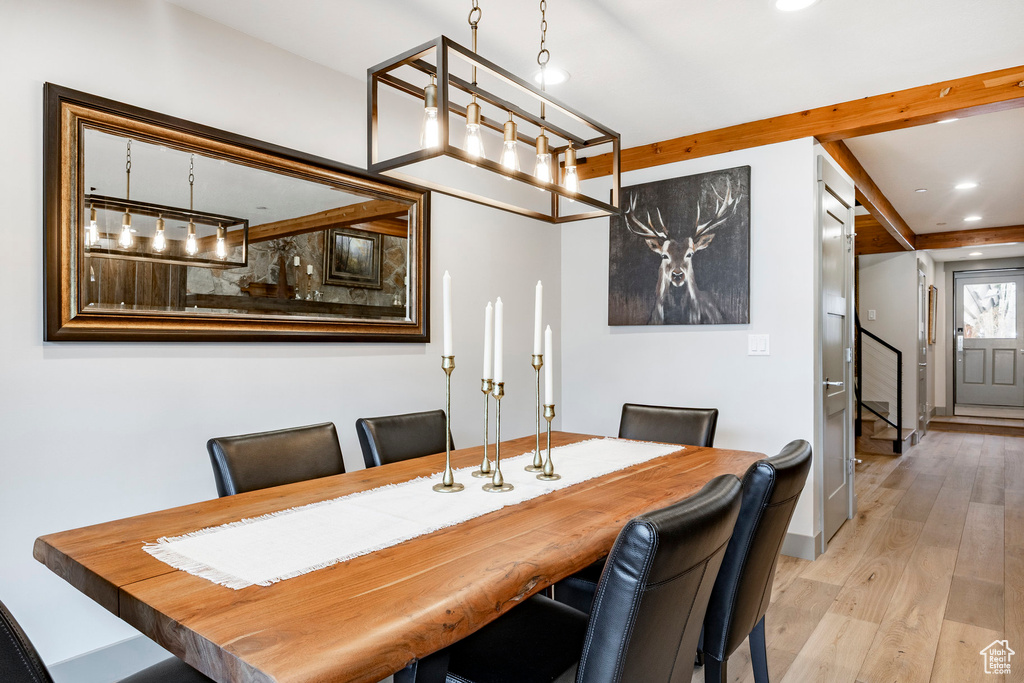 Dining space with recessed lighting, wood finished floors, and stairway