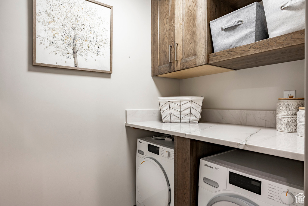 Laundry area featuring cabinet space and washer and dryer