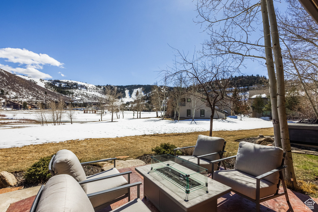 Snow covered patio featuring a fire pit and a mountain view