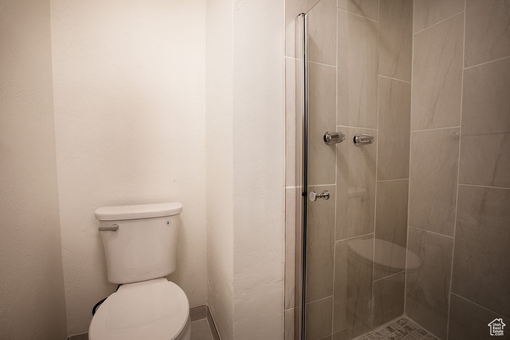 Full bath with toilet and a tile shower