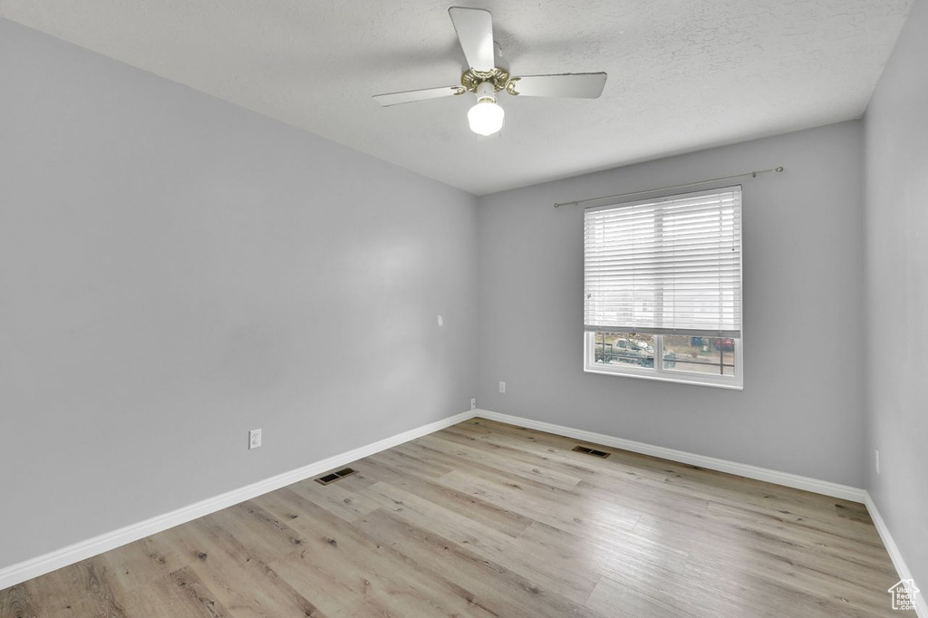 Spare room with baseboards, visible vents, and wood finished floors