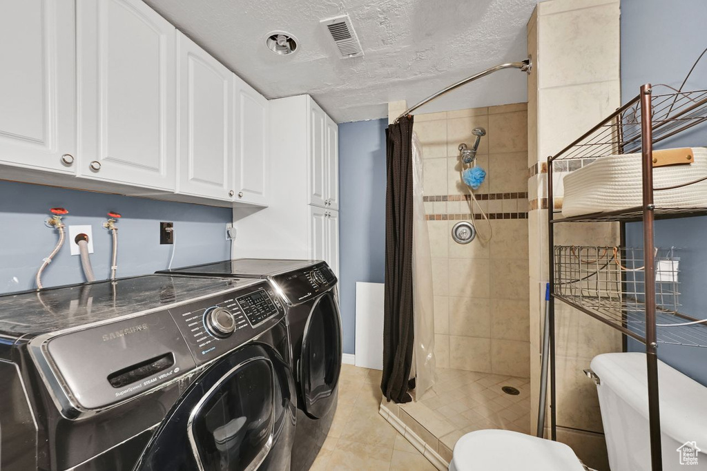 Laundry room with visible vents, washing machine and clothes dryer, laundry area, and a textured ceiling