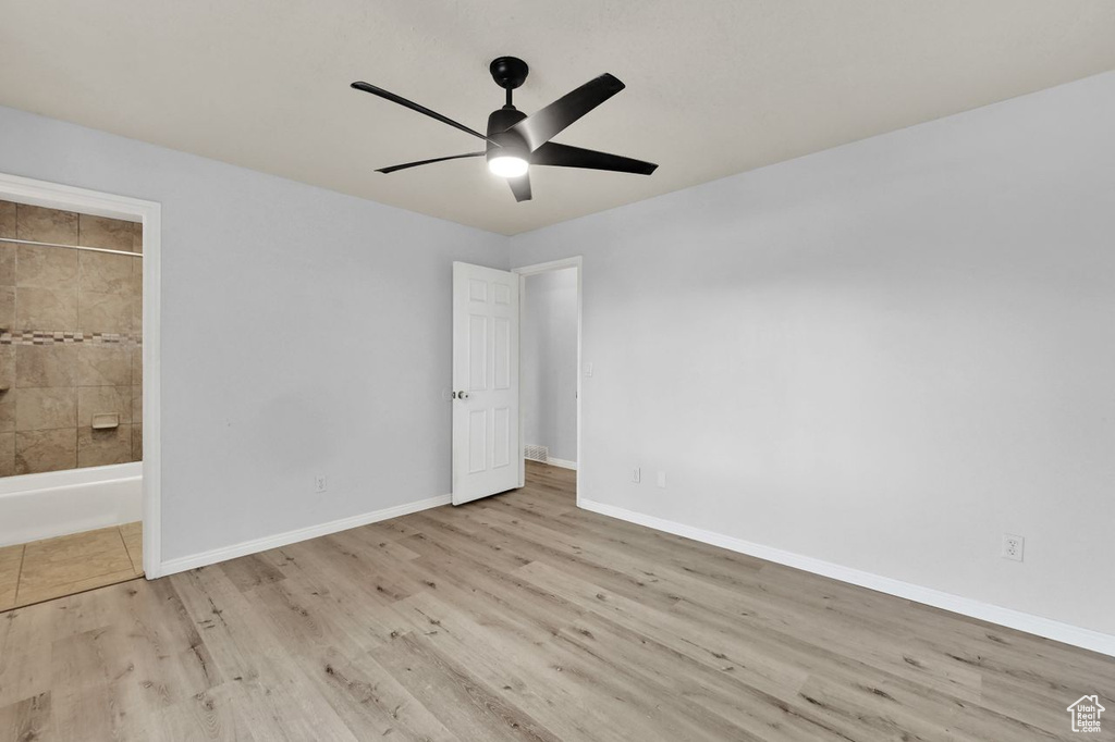 Unfurnished bedroom with baseboards, ensuite bath, and wood finished floors