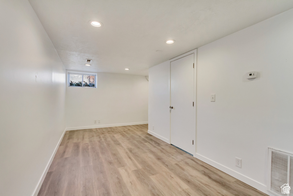 Basement featuring recessed lighting, light wood-style floors, baseboards, and visible vents