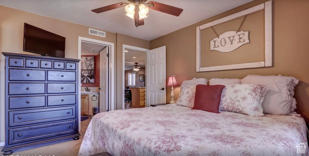 Bedroom with carpet floors, connected bathroom, ceiling fan, and visible vents