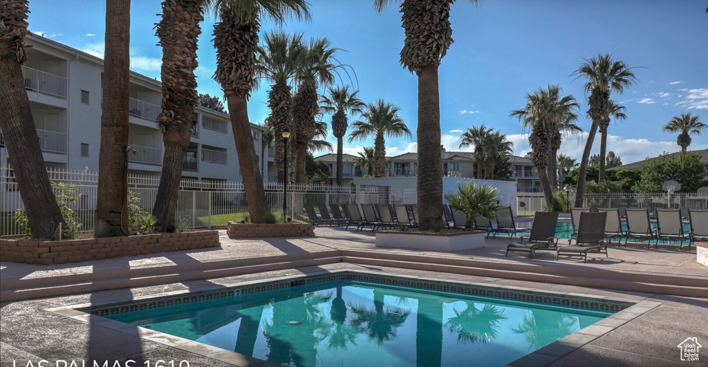 Community pool with a patio area, a residential view, and fence