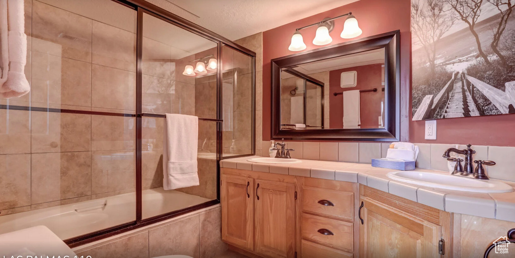Bathroom featuring double vanity, a sink, and tiled shower / bath