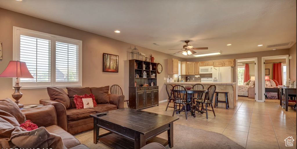 Living room with a ceiling fan, light tile patterned floors, a healthy amount of sunlight, and recessed lighting