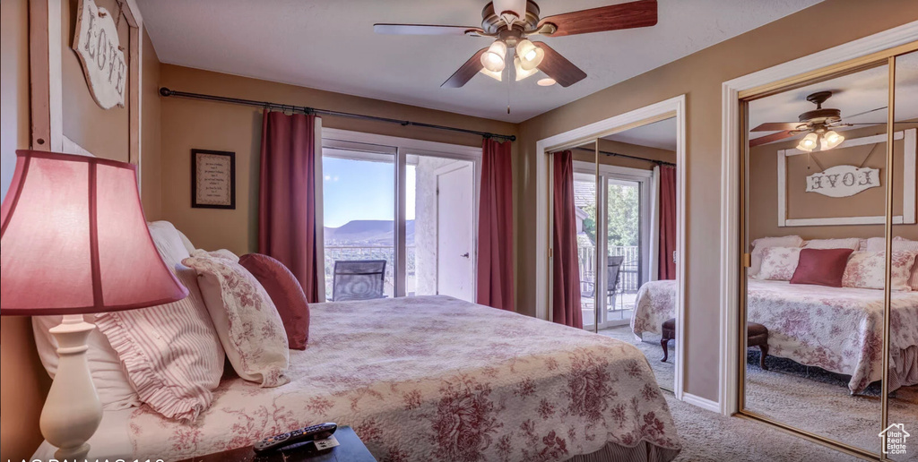 Carpeted bedroom with a ceiling fan and multiple closets