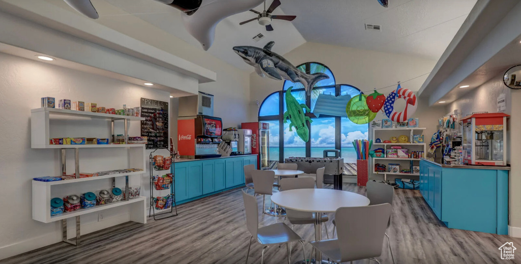 Dining area with lofted ceiling, visible vents, wood finished floors, and a ceiling fan