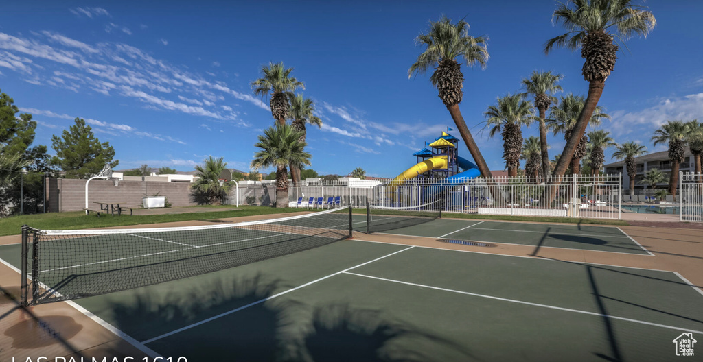 View of tennis court with fence and playground community