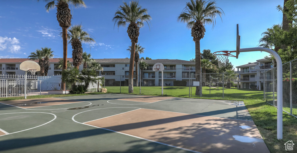 View of sport court with a residential view, community basketball court, fence, and a yard