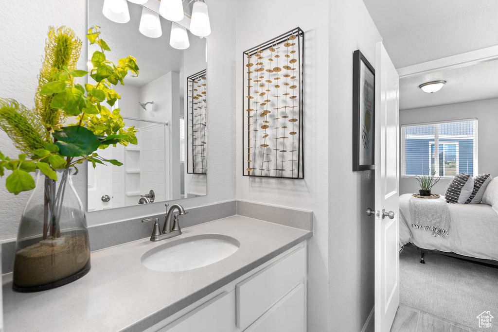 Full bath featuring ensuite bathroom, a shower, and vanity