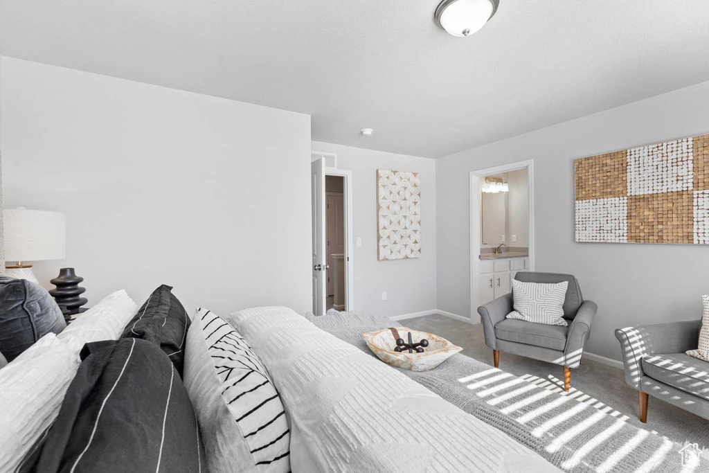 Carpeted bedroom featuring baseboards and ensuite bath