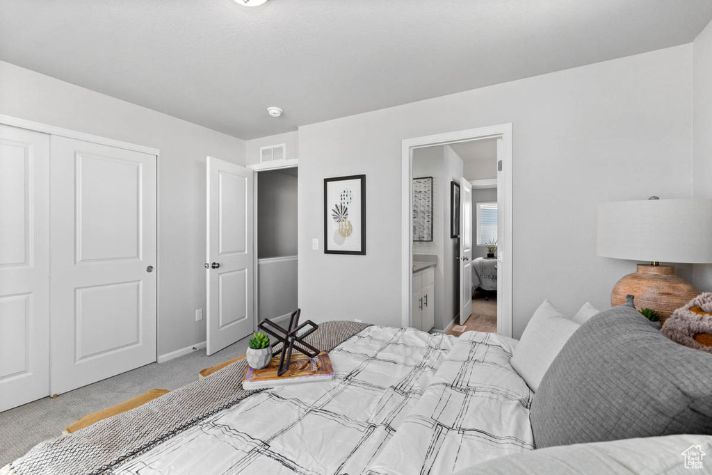 Carpeted bedroom featuring baseboards, visible vents, and a closet