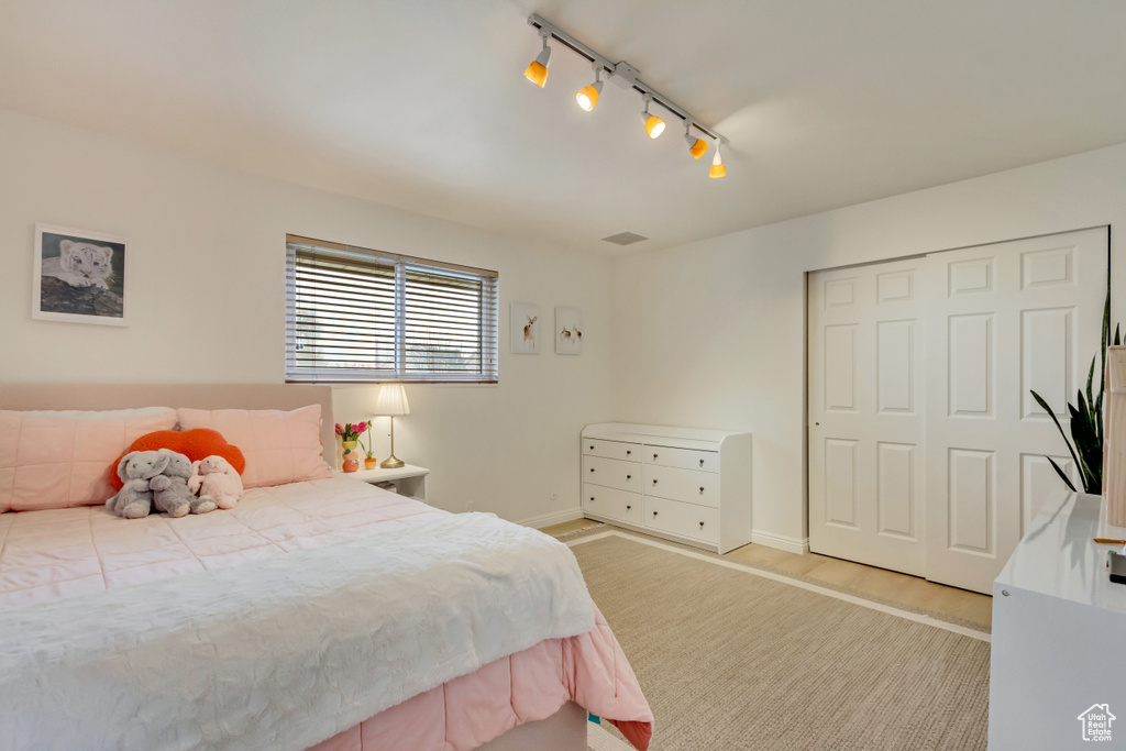 Bedroom with a closet, baseboards, and wood finished floors