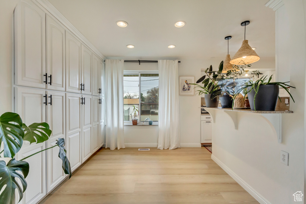 Interior space with baseboards, recessed lighting, and light wood-style floors