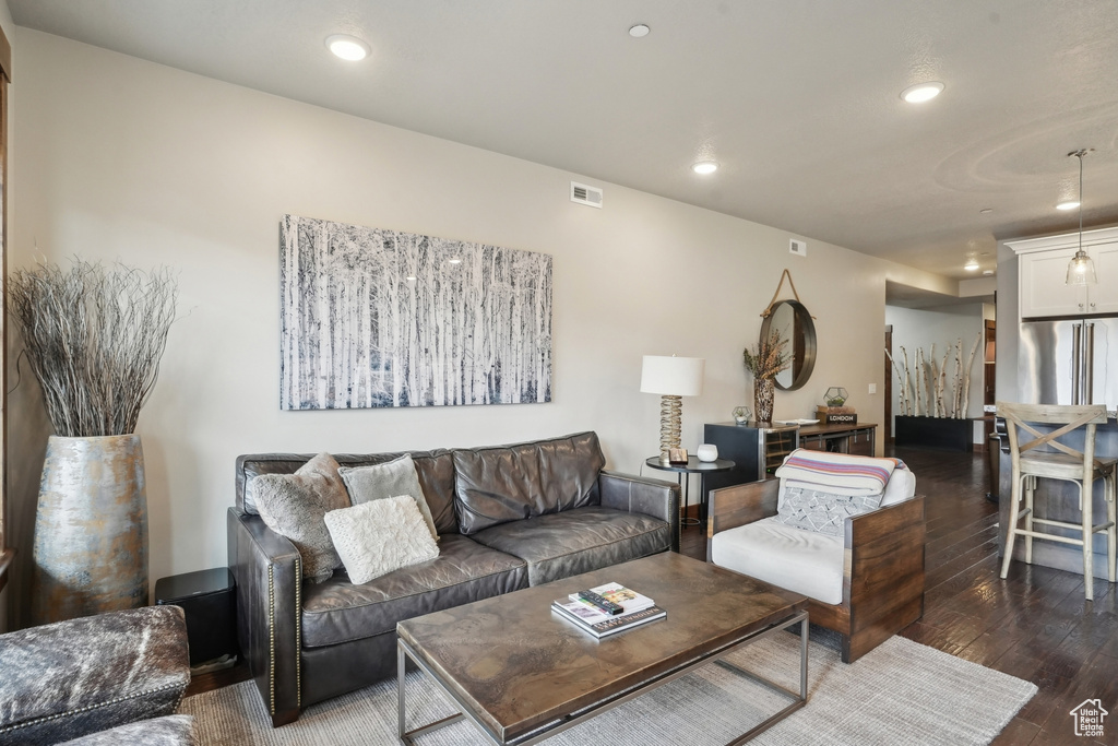 Living area featuring wood-type flooring, recessed lighting, and visible vents