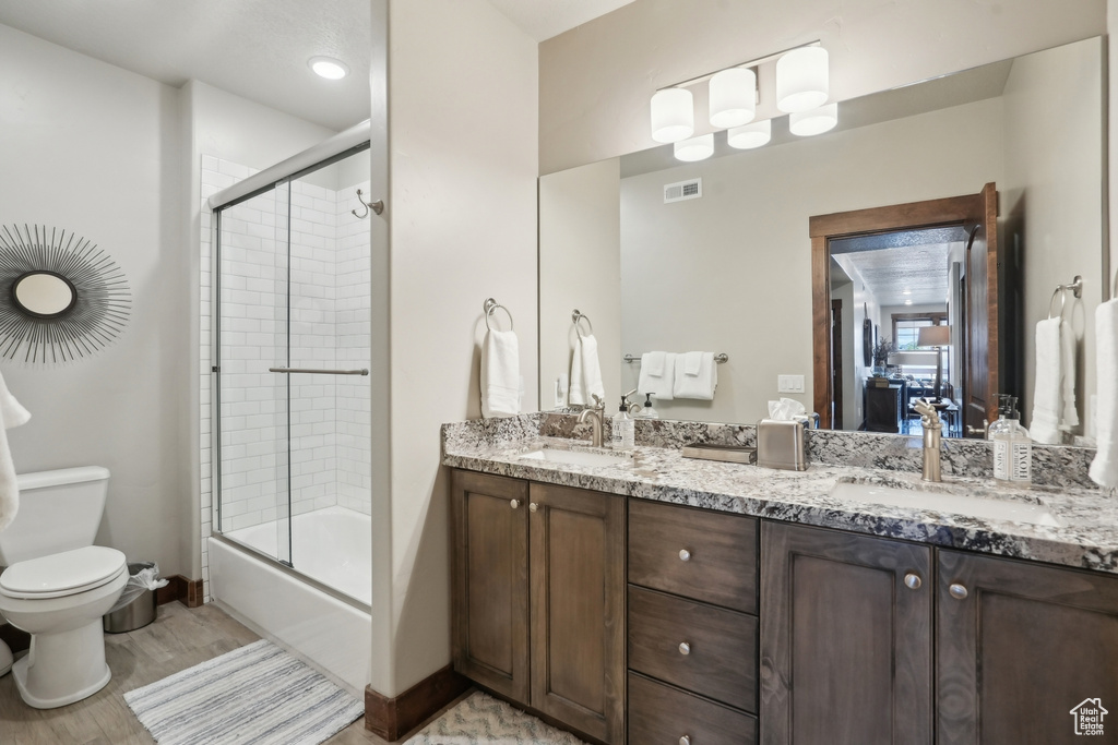 Full bathroom featuring double vanity, visible vents, toilet, and a sink