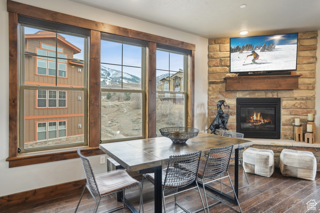Dining room with hardwood / wood-style floors, baseboards, and a fireplace