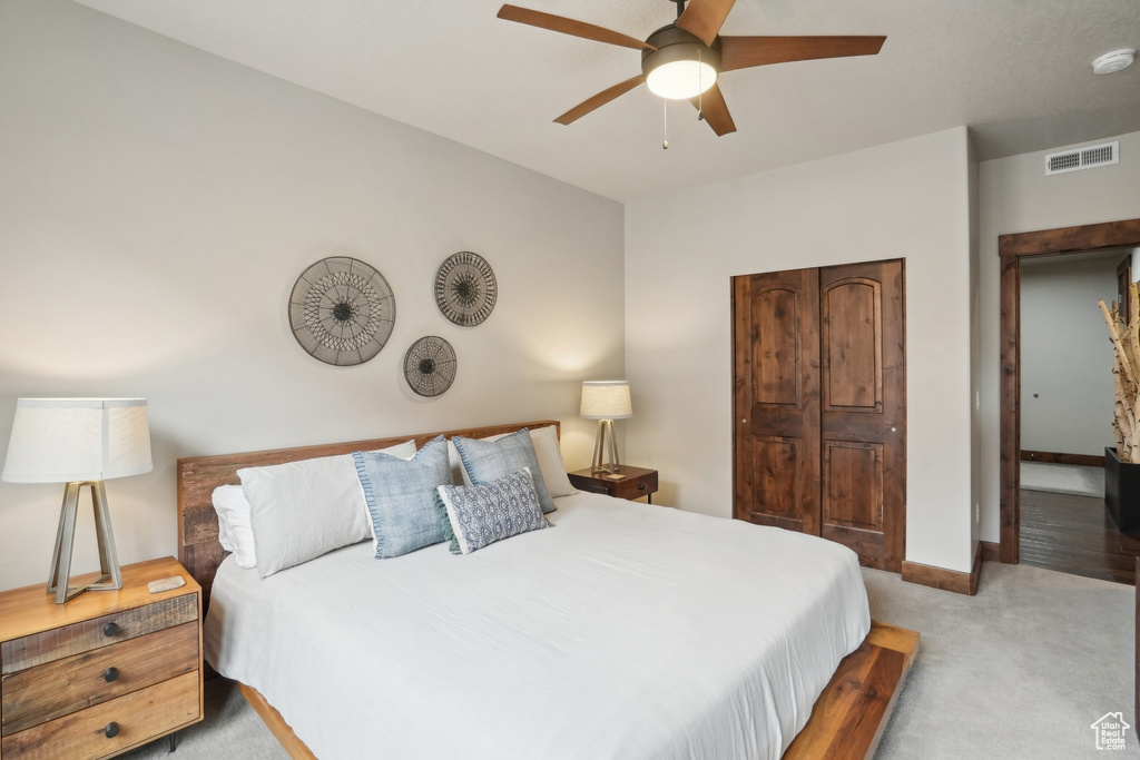 Carpeted bedroom featuring baseboards, visible vents, and ceiling fan