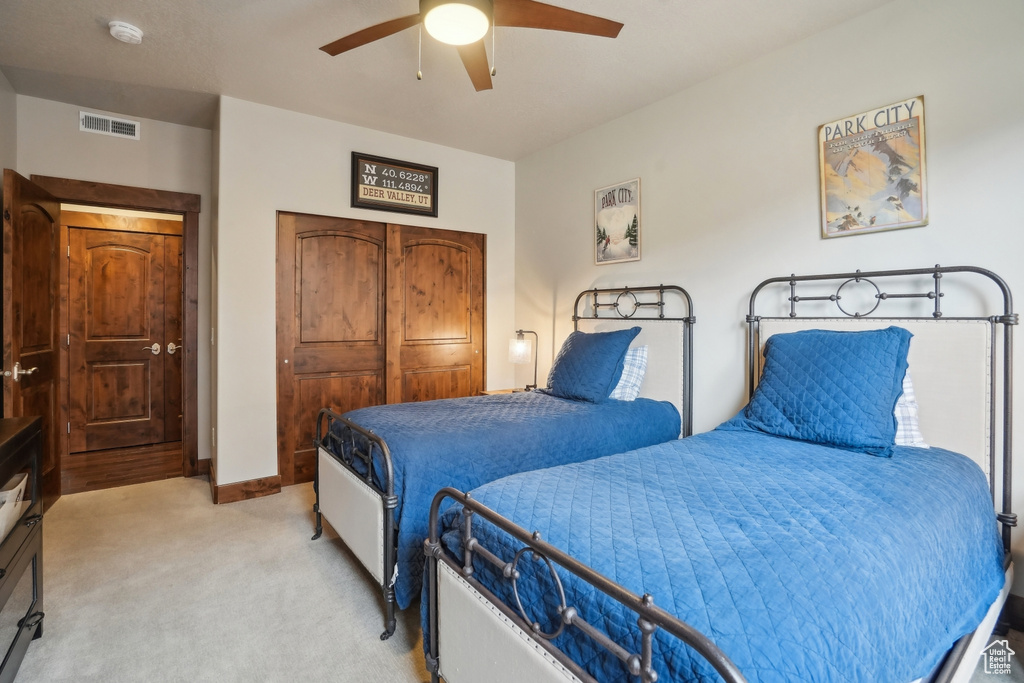 Bedroom with baseboards, visible vents, a ceiling fan, light carpet, and a closet