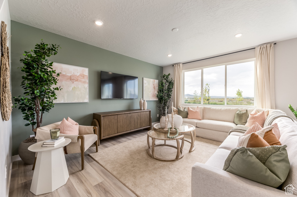 Living room featuring recessed lighting, a textured ceiling, and light wood-type flooring