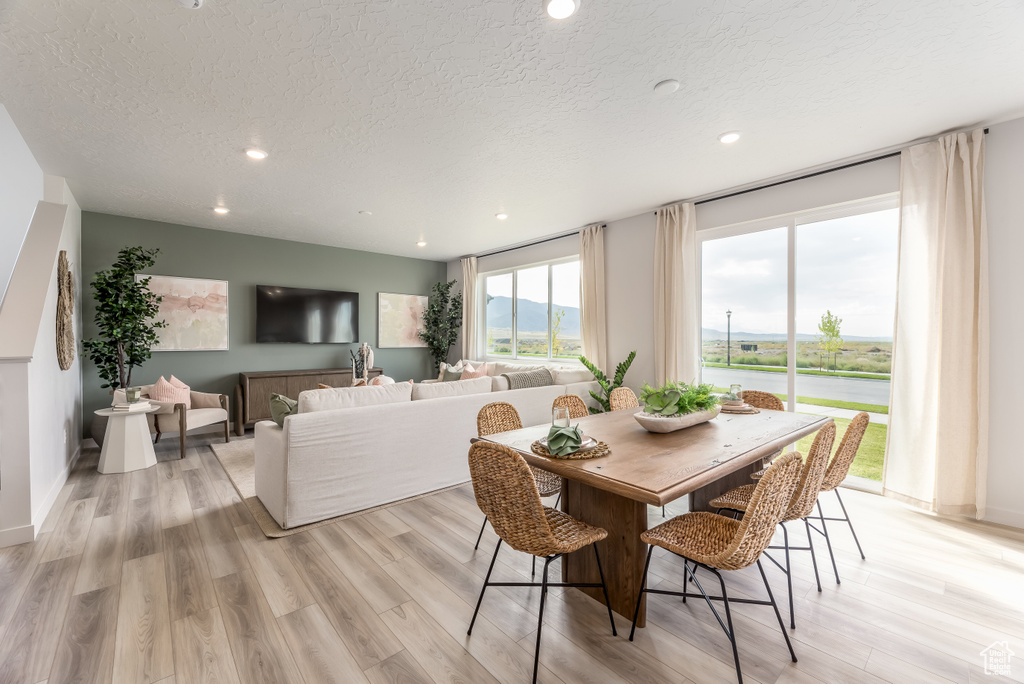 Dining space featuring light wood-style floors, recessed lighting, and a textured ceiling