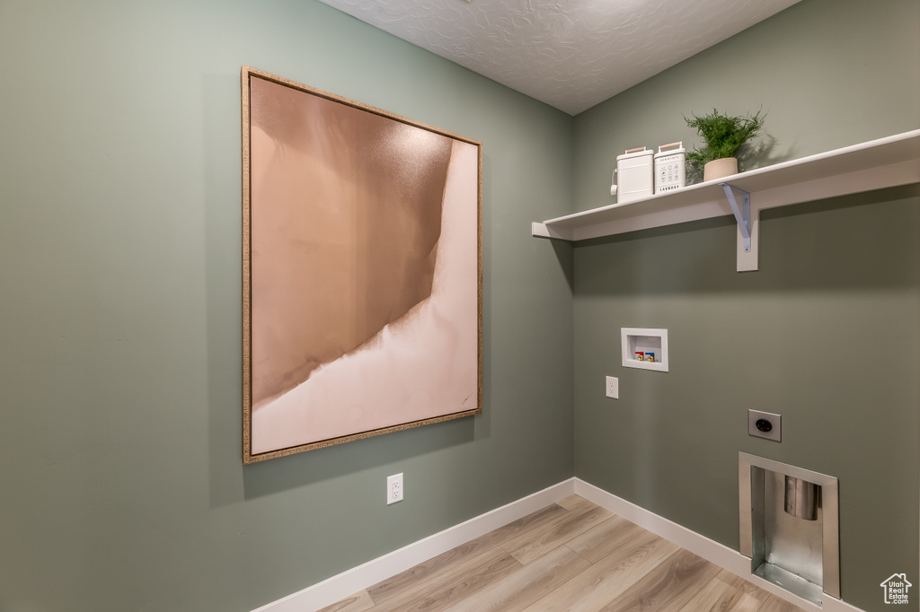 Laundry area with washer hookup, light wood-type flooring, hookup for an electric dryer, laundry area, and baseboards