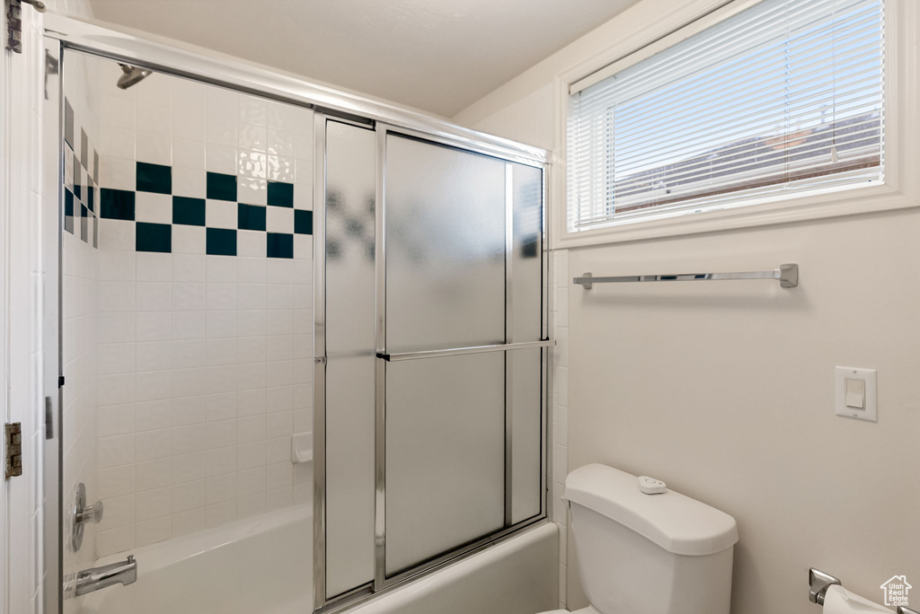 Bathroom with enclosed tub / shower combo and toilet