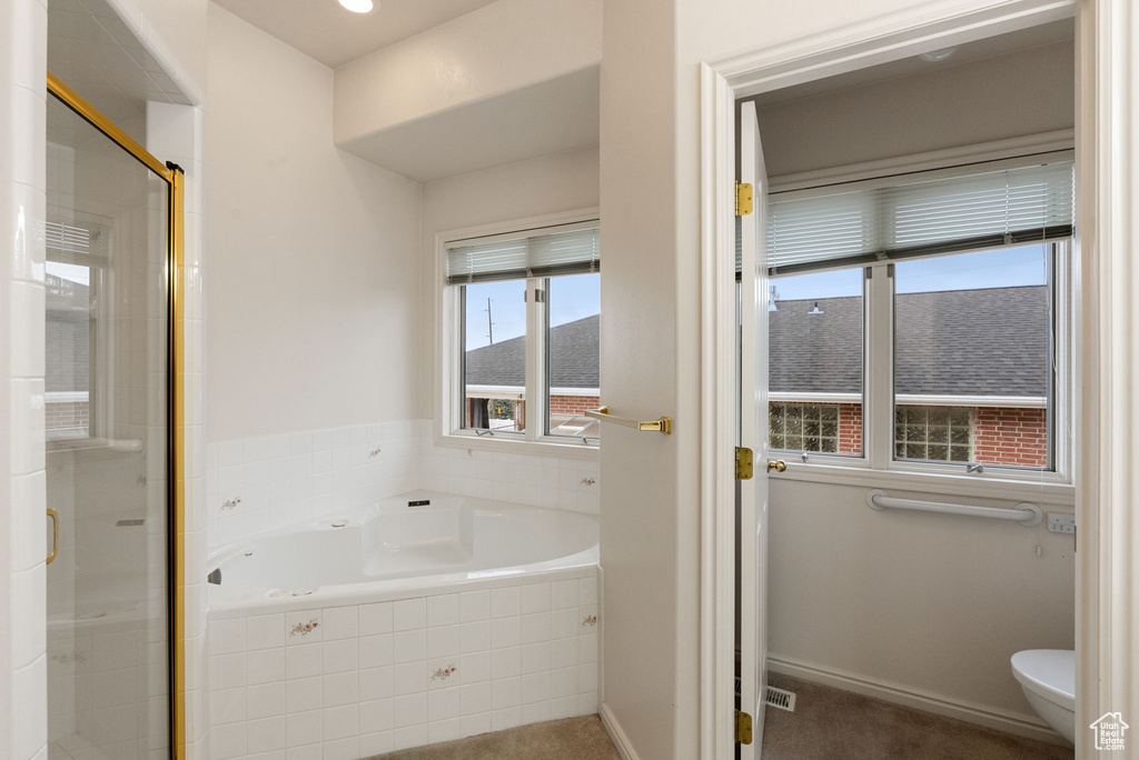 Full bath featuring a stall shower, baseboards, toilet, and a garden tub