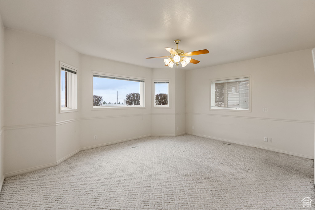 Unfurnished room with baseboards, ceiling fan, and carpet