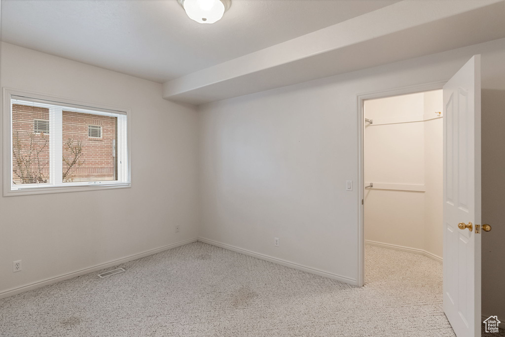 Spare room with light colored carpet, visible vents, and baseboards