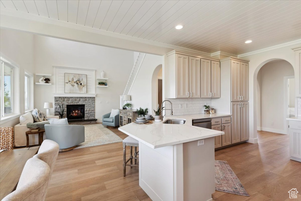 Kitchen featuring a sink, arched walkways, a breakfast bar area, and open floor plan