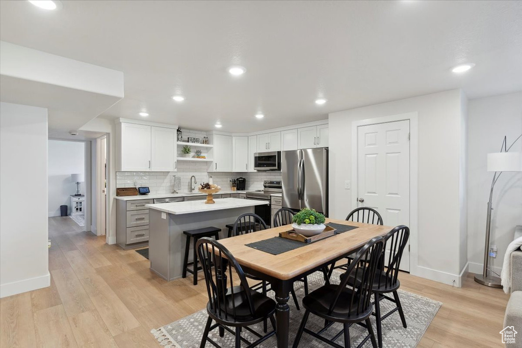 Dining room with recessed lighting, baseboards, and light wood-type flooring
