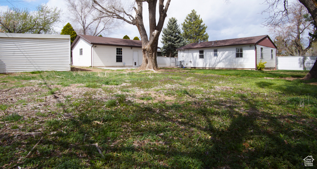 View of yard with an outdoor structure and fence