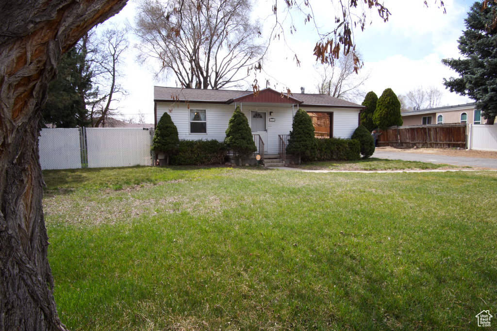 View of front facade featuring fence and a front yard