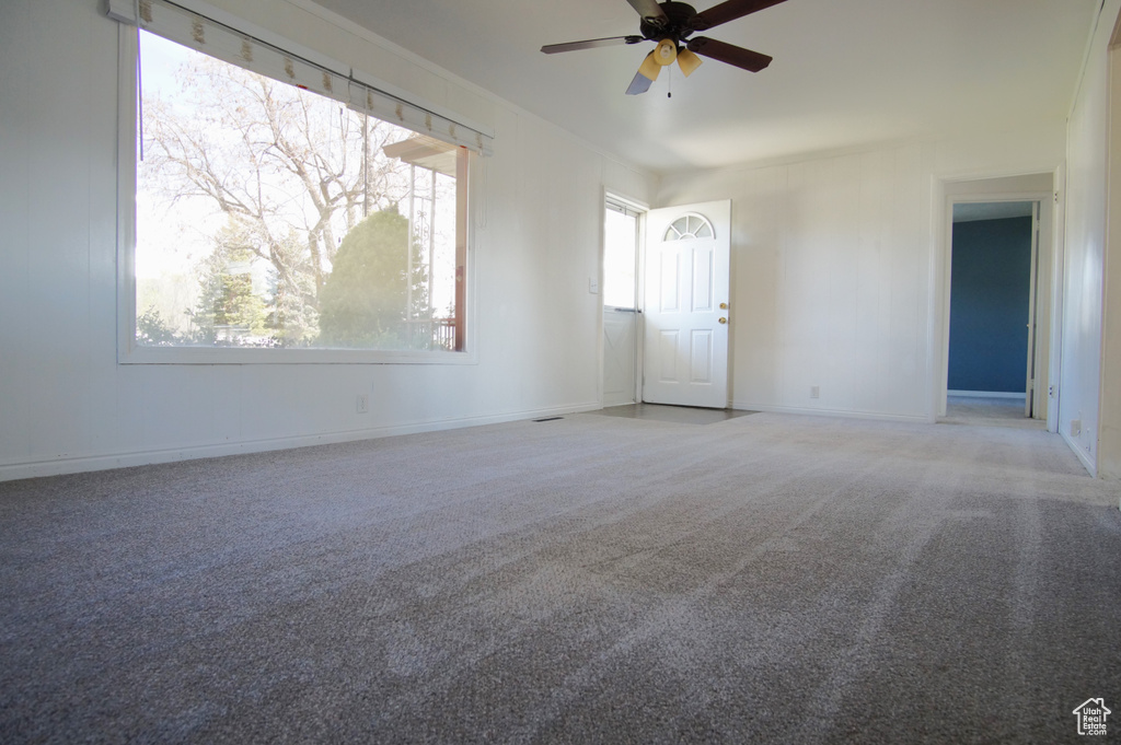 Carpeted empty room with baseboards and ceiling fan